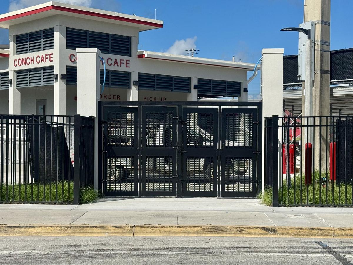 Black aluminum double gates with privacy screening at a commercial site