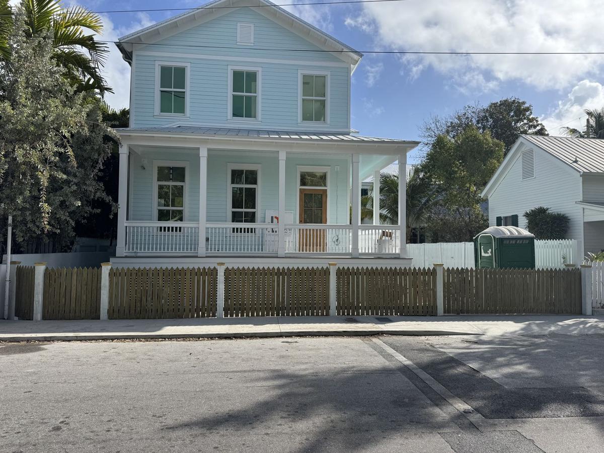 Wood picket fence with white posts in front of a Keys home